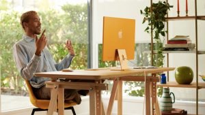 člověk používající žlutý počítač Apple iMac