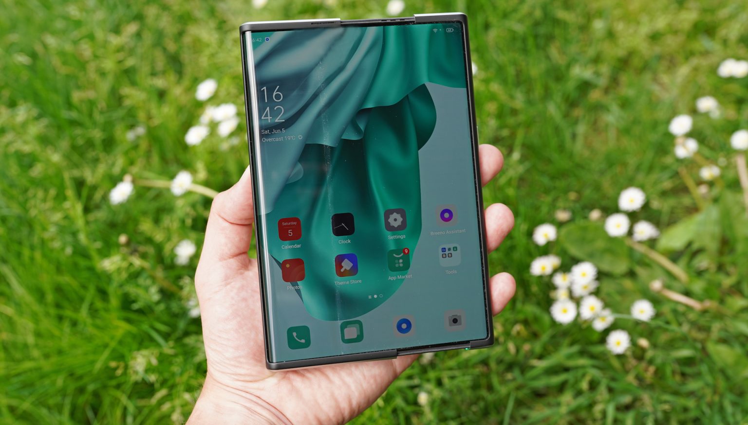Roztažený rolovací smartphone OPPO X 2021 Roztažený rolovací smartphone OPPO X 2021 držený v ruce
