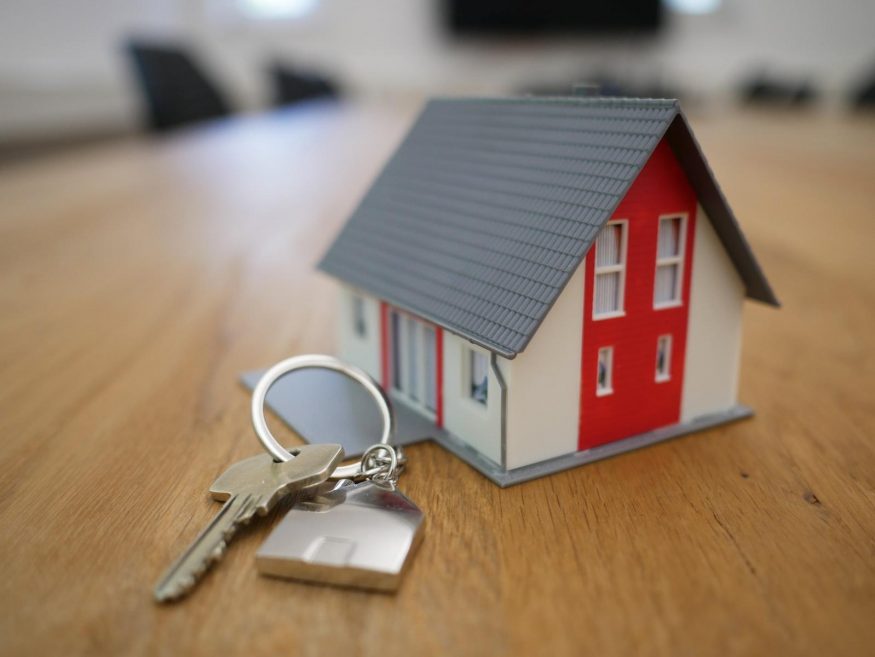 mortgage white and red wooden house miniature on brown table