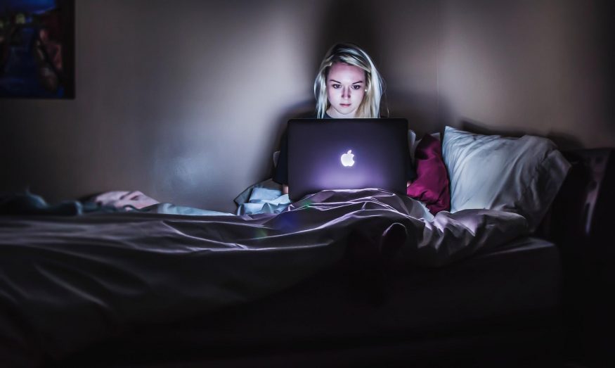 žena v posteli s macbookem