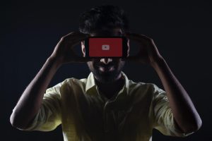 Youtube, man holding black Android smartphone
