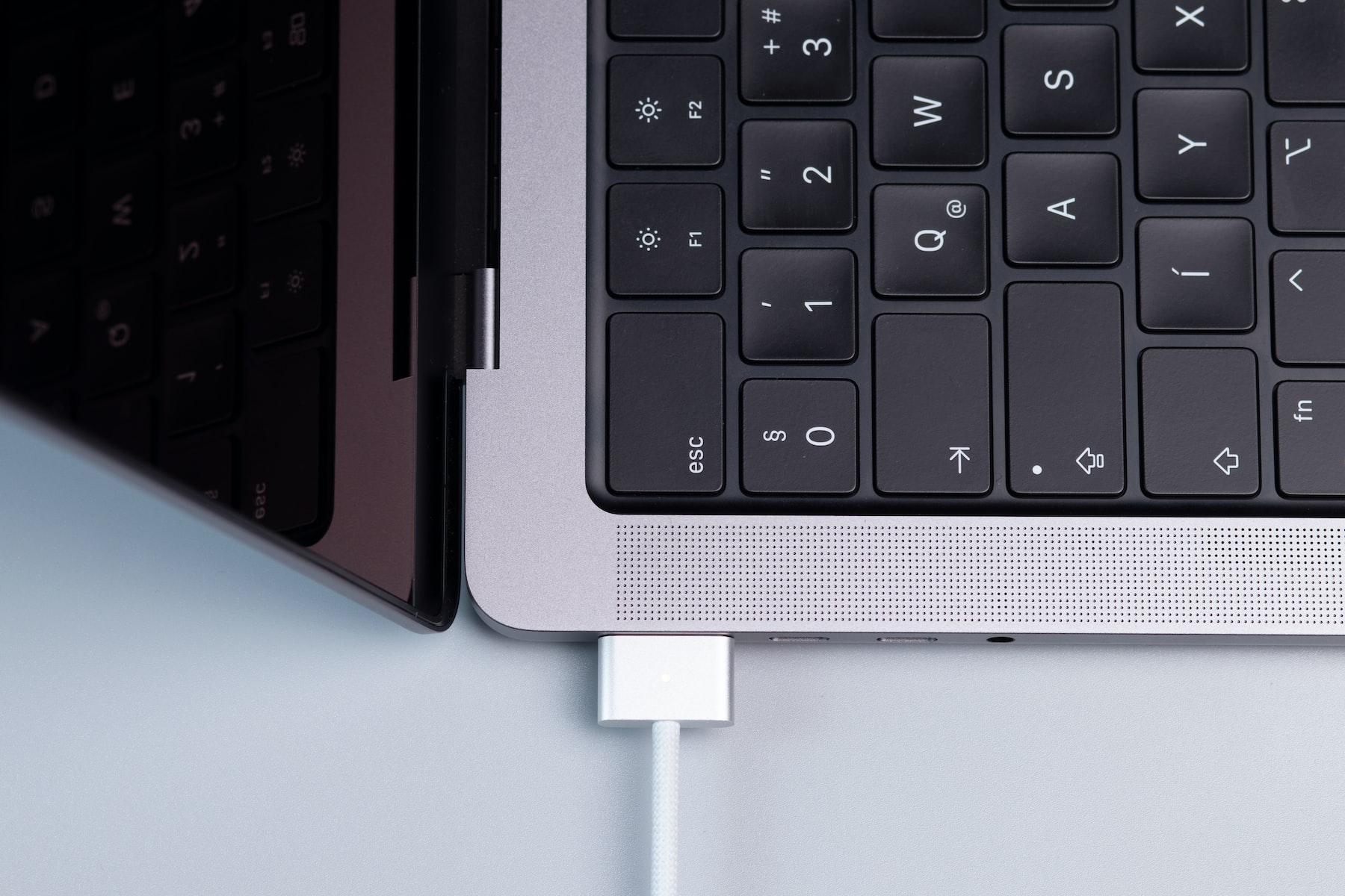 počítač macbook společnosti apple připojený k napájení kabelem magsafe