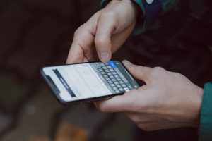 člověk používající virtuální klávesnici chytrého telefonu