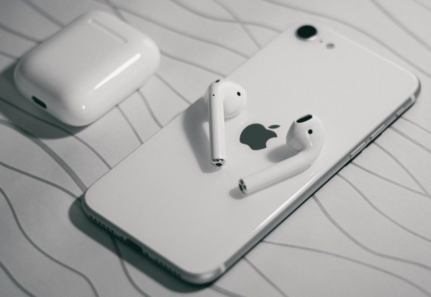 bílý iPhone se 2022 se sluchátky AirPods