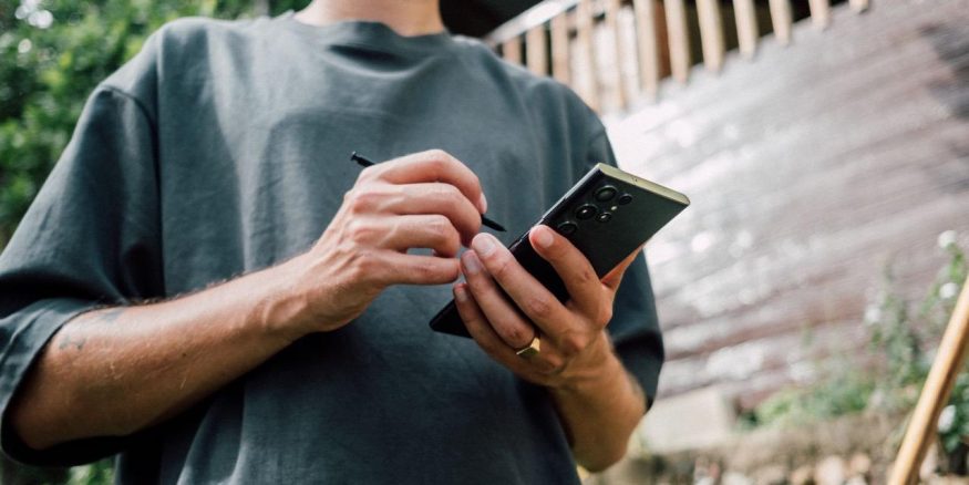Muž držící chytrý telefon Samsung Galaxy S23 Ultra