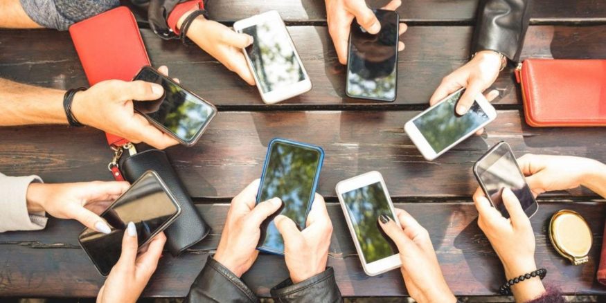 Skupina lidí držící smartphony