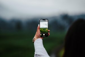 Člověk fotografující přírodu na svůj chytrý telefon