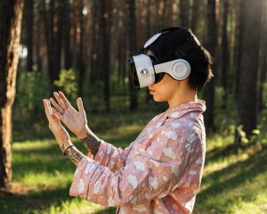 Žena v lese s nasazeným headsetem pro virtuální realitu
