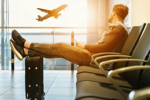 Muž sedící na letišti a čekající na letadlo
