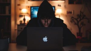 Hacker za MacBookem (ilustrační obrázek)
