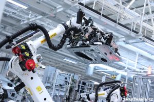 Robot ke karoserii připevňuje další díl (dveře)