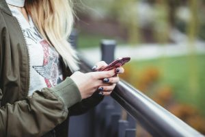 Žena držící chytrý telefon ve svých rukou