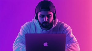 Mladý člověk s MacBookem (ilustrační obrázek)