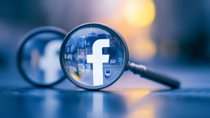 Logo společnosti Facebook pod lupou (ilustrační obrázek)