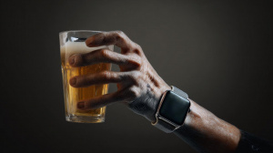Lidská ruka s Apple Watch držící pivo (ilustrační obrázek)