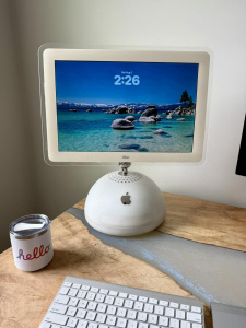 Počítač iMac G4 s operačním systémem macOS 26 a designovým jazykem Liquid Glass