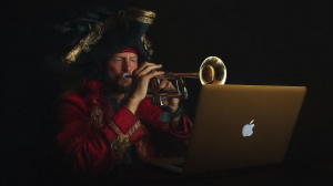 Pirát hrající na trumpetu za notebookem (ilustrační obrázek)