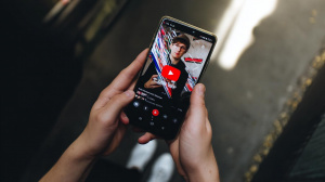 Mobilní aplikace YouTube na chytrém telefonu v rukou uživatele (ilustrační obrázek)