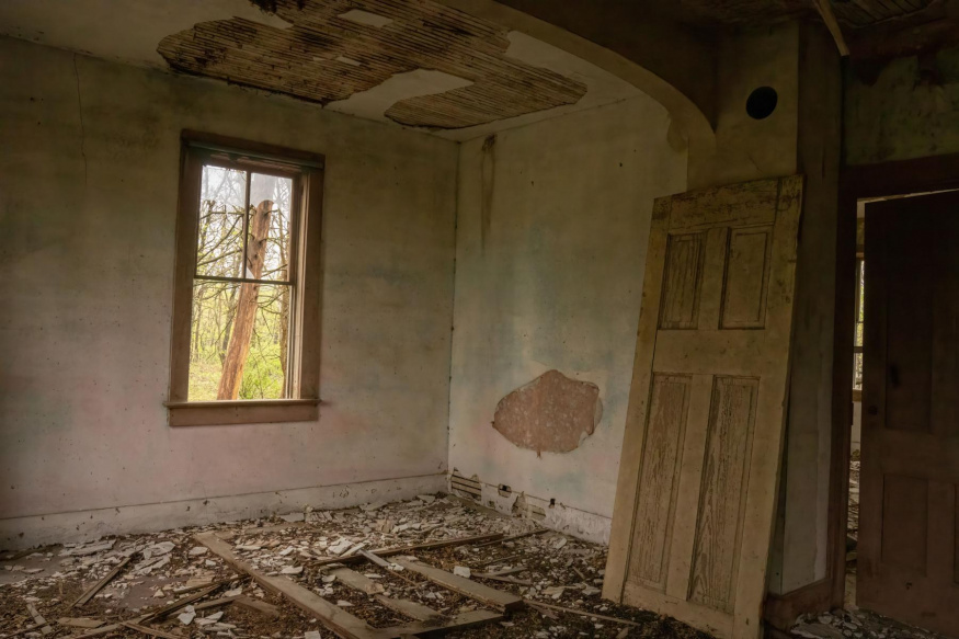Zanedbaný interiér s poškozeným stropem a zdmi