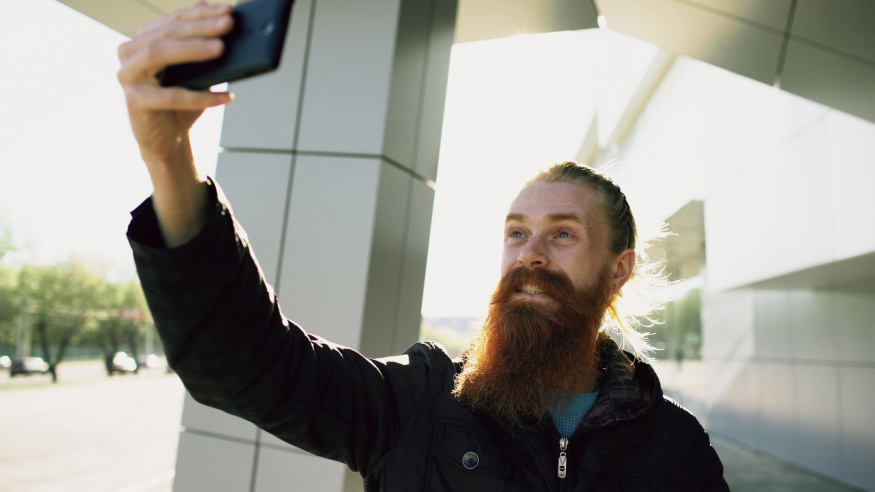 Muž si venku pořizuje selfie smartphonem