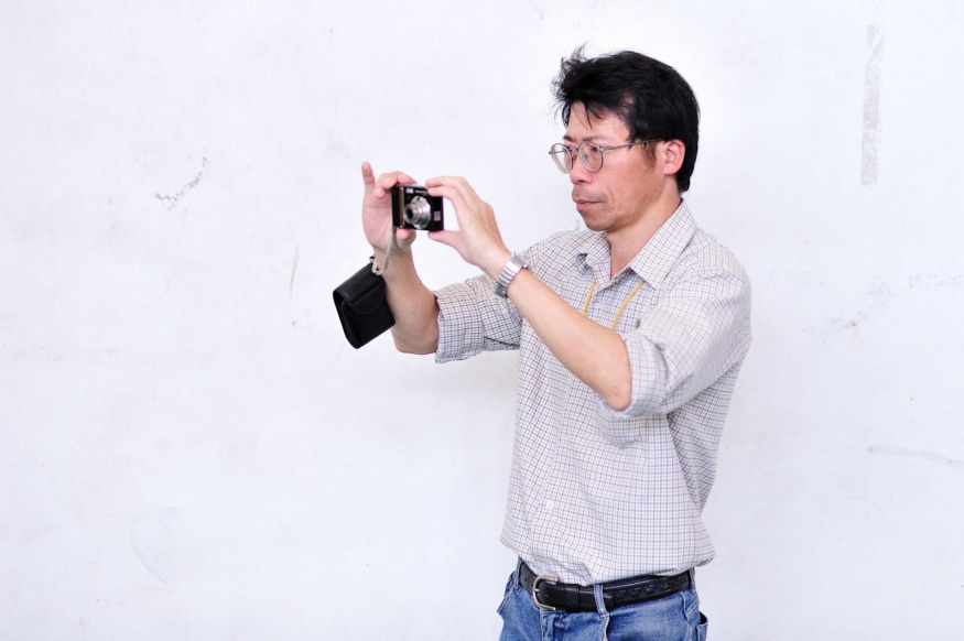 Samostatný kompakt vede k vědomějšímu focení Muž fotografuje malým digitálním kompaktem