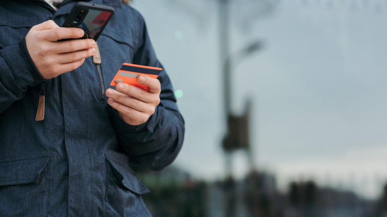Člověk zadává údaje z platební karty do smartphonu