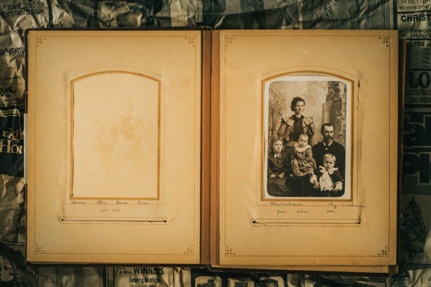 Staré rodinné album Otevřené staré rodinné album s jednou vloženou černobílou rodinnou fotografií
