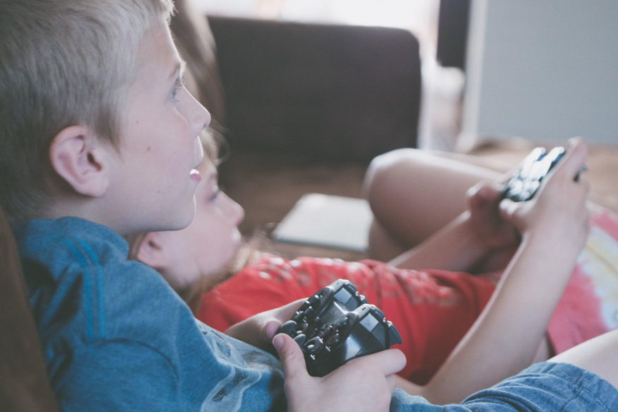 Děti při hraní videohry Dvě děti hrají videohru s ovladači
