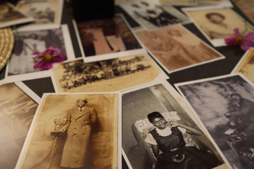 Sbírka starých rodinných fotografií Na stole jsou rozložené staré černobílé a sépiové rodinné fotografie