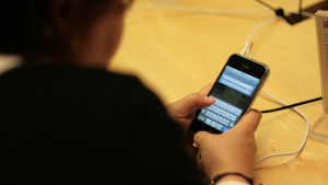 Softwarová klávesnice původního iPhonu Člověk ovládá původní iPhone pomocí softwarové klávesnice na dotykovém displeji