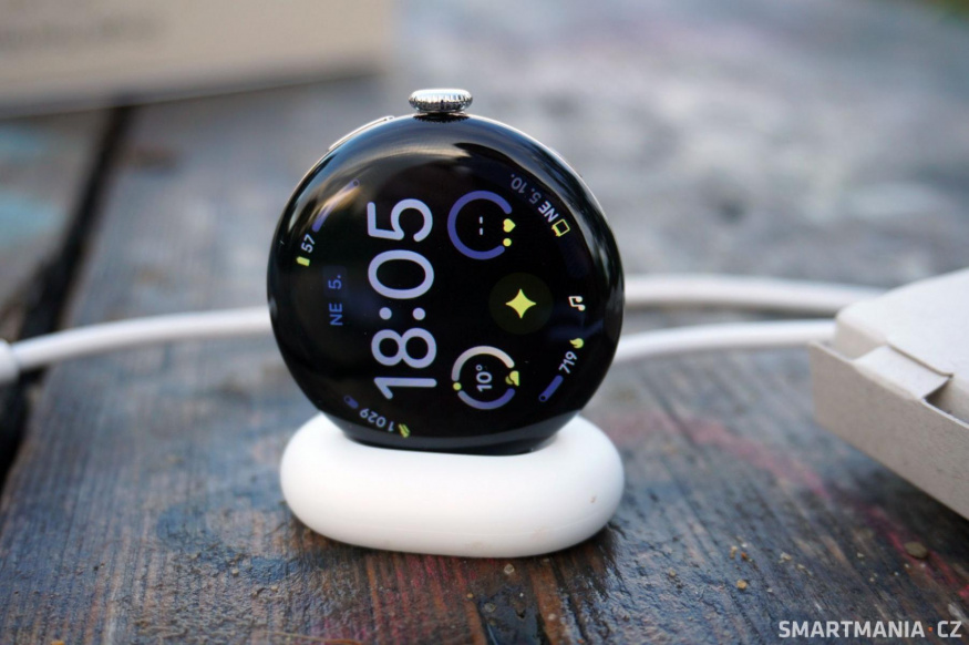 Google Pixel Watch 4 na nabíječce Google Pixel Watch 4 položené na nabíjecí kolébce