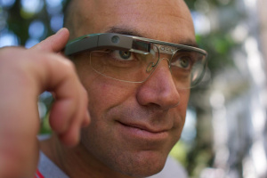 Muž s nasazenými Google Glass se dotýká ovládací plochy na pravé straně brýlí