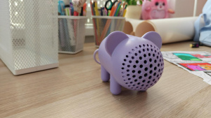 Fialový reproduktor IKEA GREJSIMOJS ve tvaru myši na pracovním stole