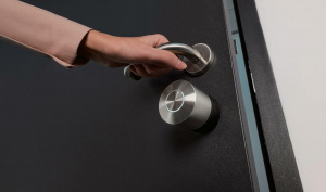 Ruka na klice vstupních dveří s chytrým zámkem Nuki Smart Lock Pro