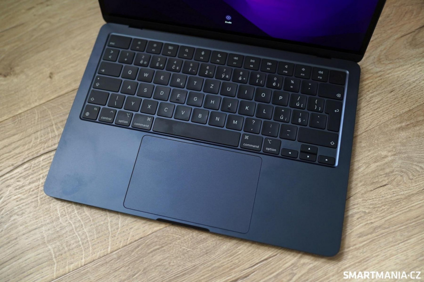 Otisky na tmavém MacBooku Air M2 Klávesnice a trackpad tmavého MacBooku Air M2 s viditelnými otisky na opěrkách dlaní