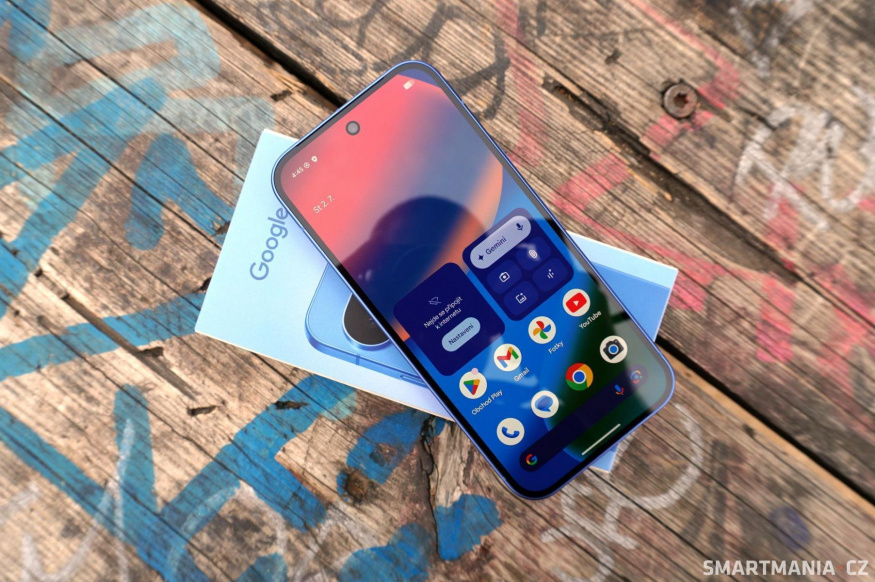 Google Pixel 10 v modré barvě Modrý Google Pixel 10 položený na krabičce displejem vzhůru