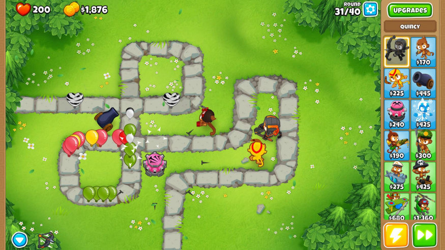 Obrana cesty v Bloons TD 6 Balónky procházejí mezi obrannými jednotkami na mapě ve hře Bloons TD 6