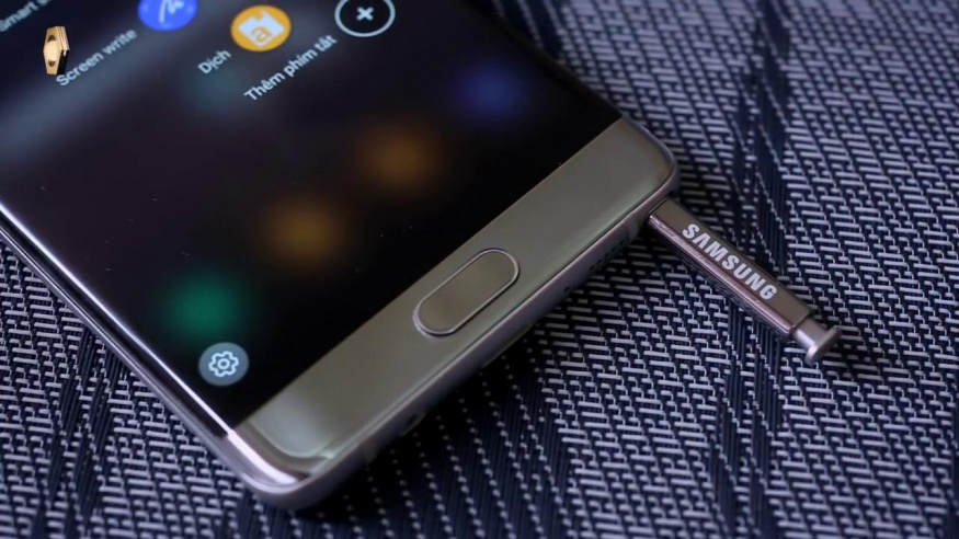 Samsung Galaxy Note FE s perem S Pen Detail spodní části Samsungu Galaxy Note FE s domovským tlačítkem a částečně vysunutým perem S Pen