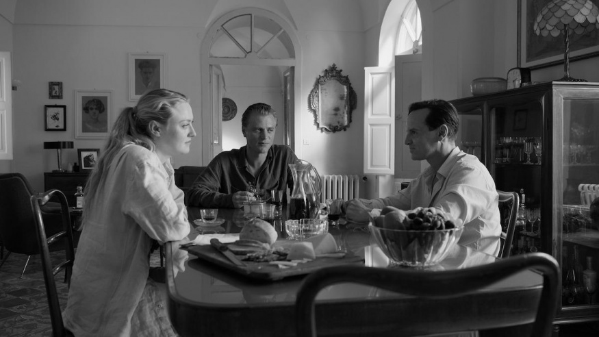 Ripley – oficiální fotografie Netflixu Dakota Fanningová, Johnny Flynn a Andrew Scott sedí u stolu ve scéně ze seriálu Ripley