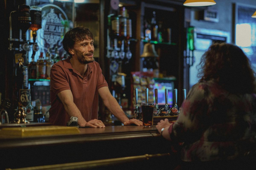 Sobík – oficiální fotografie Netflixu Richard Gadd jako Donny Dunn mluví s Marthou v baru v seriálu Sobík