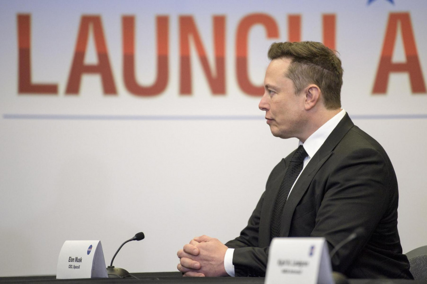 Elon Musk na briefingu před misí Demo-2 Elon Musk sedí u stolu během briefingu NASA a SpaceX