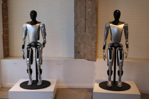 Dva roboti Tesla Optimus ve Stockholmu Dva černostříbrní humanoidní roboti Tesla Optimus stojí na podstavcích