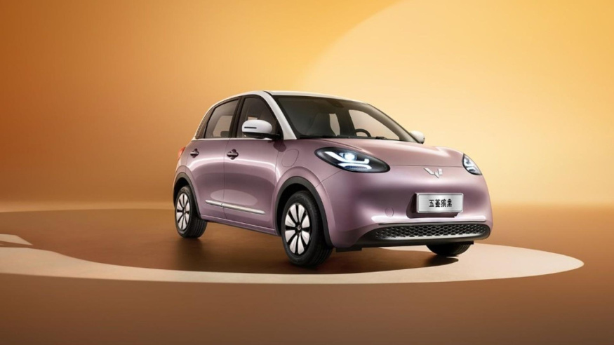 Wuling Bingo Fialový Wuling Bingo s bílou střechou před teplým oranžovým studiovým pozadím