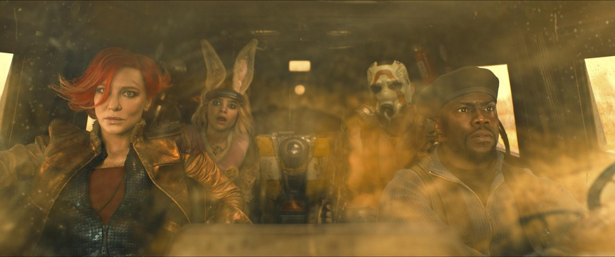 Akční scéna z Borderlands Cate Blanchett jako Lilith a Kevin Hart jako Roland v popředí scény s kouřem, za nimi Tiny Tina, Claptrap a Krieg