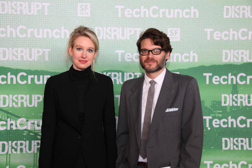 Elizabeth Holmesová, zakladatelka Theranosu Elizabeth Holmesová vlevo v černém roláku před zelenou stěnou TechCrunch