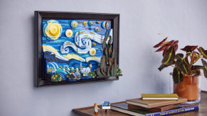 LEGO model Hvězdné noci zavěšený na šedé stěně nad knihami a minifigurkou Van Gogha