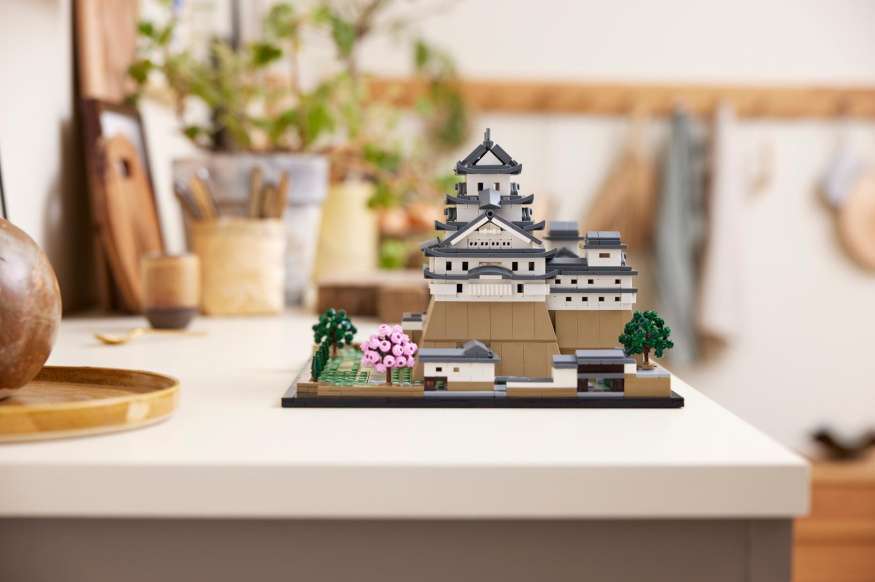 LEGO Hrad Himedži v interiéru LEGO hrad Himedži s bílými zdmi, tmavými střechami a růžově kvetoucí třešní na světlé desce