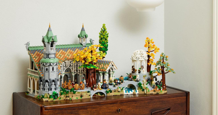 LEGO Roklinka na dřevěné komodě Celý LEGO model Roklinky s elfími budovami, barevnými střechami a žlutými stromy na dřevěné komodě