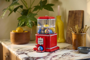 LEGO automat na minifigurky Červený LEGO automat s průhledným zásobníkem a modrou kapslí ve výdejním otvoru na kuchyňské desce