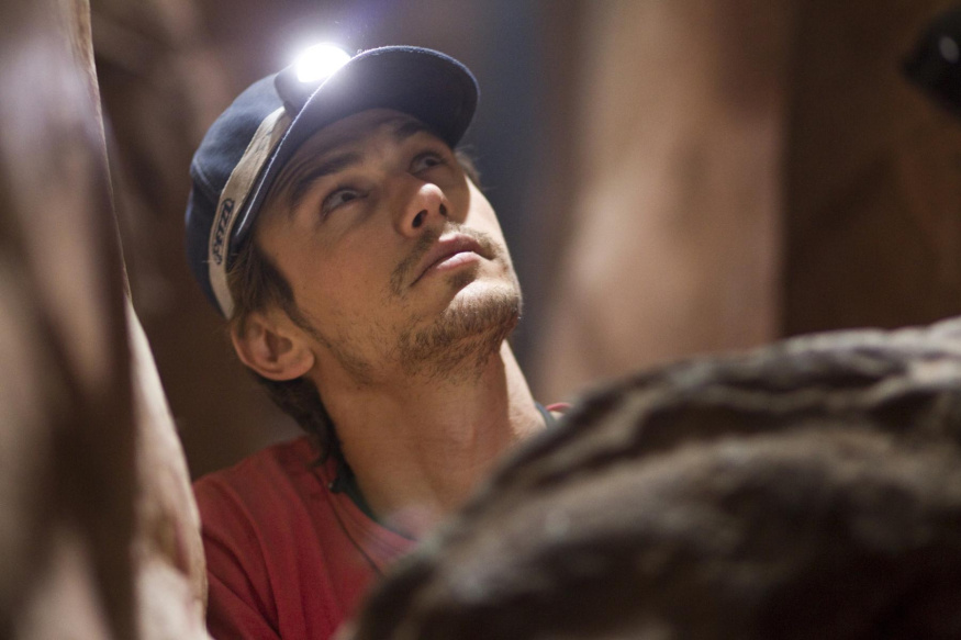 127 hodin: James Franco James Franco s čelovkou v úzké skalní štěrbině